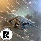 A dnd miniature ankylosaurus primed in black.
