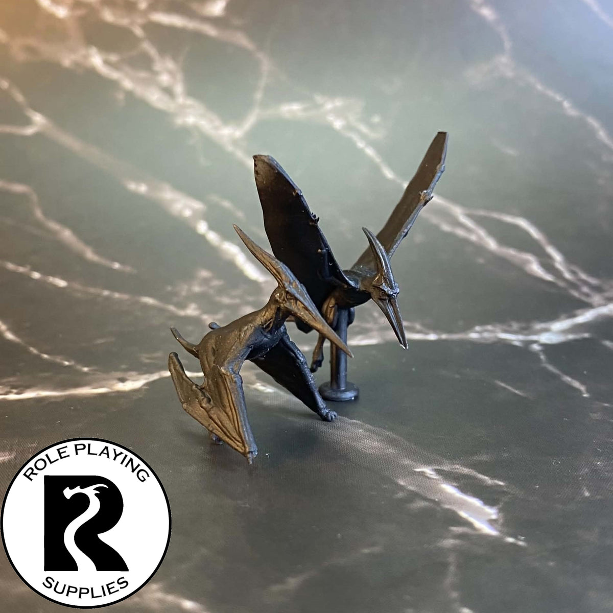 A dnd miniature pair of pteranodons primed in black.
