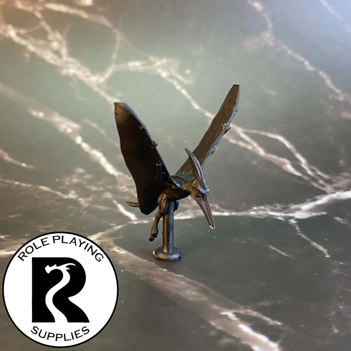 A dnd miniature pteranodon primed in black.
