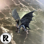 A dnd miniature young brass dragon primed in black.
